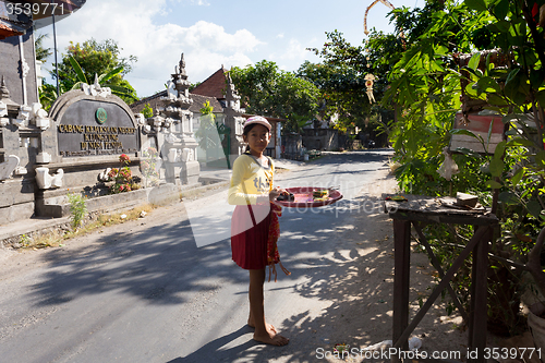 Image of indonesian girl bring offerings to the home temple