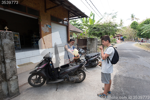 Image of Woman sell benzine in plastic bottle