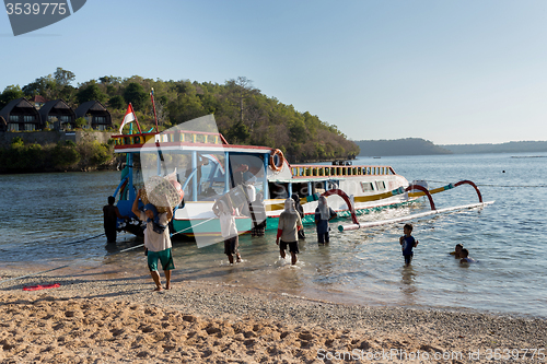 Image of Men transports cargo from ship