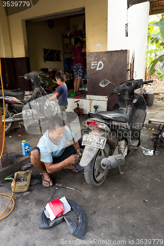 Image of Service man repair deflated damaged tyre