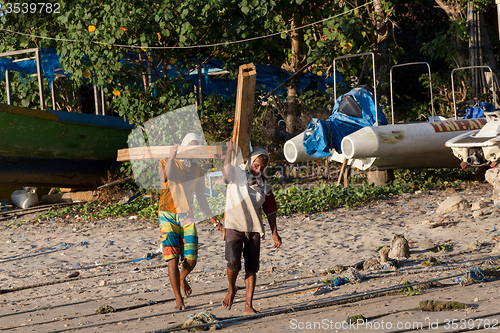 Image of Men transports cargo from ship to shipyard