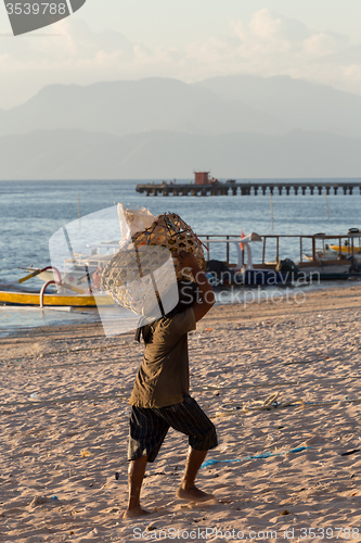 Image of Men transports cargo from ship