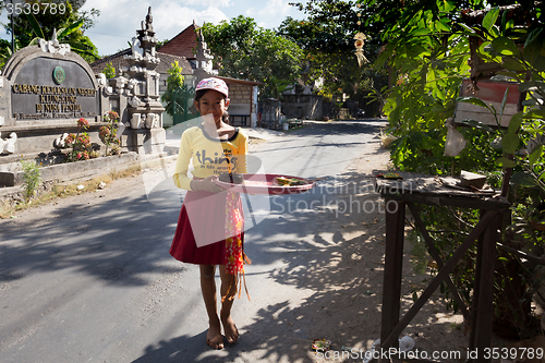 Image of indonesian girl bring offerings to the home temple