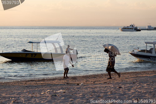 Image of Men transports cargo from ship