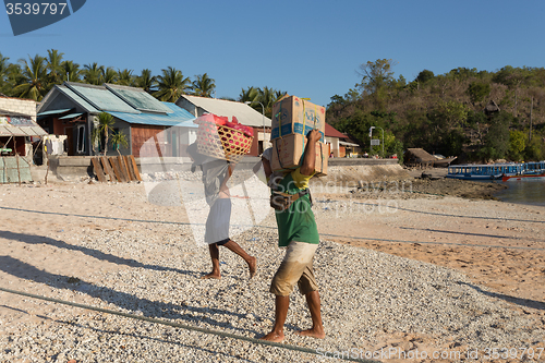 Image of Men transports cargo from ship