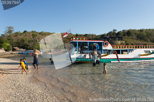 Image of Men transports cargo from ship