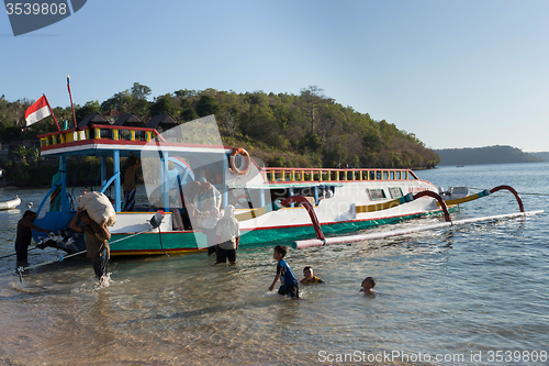 Image of Men transports cargo from ship