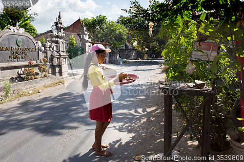 Image of indonesian girl bring offerings to the home temple