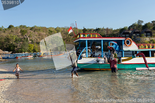 Image of Men transports cargo from ship