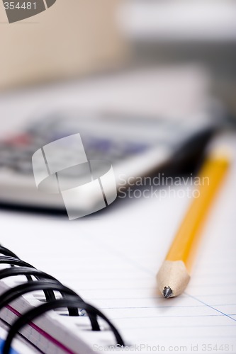 Image of pencil and calculator on notebook