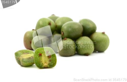 Image of Kiwi berry sliced open in front of pile of berries