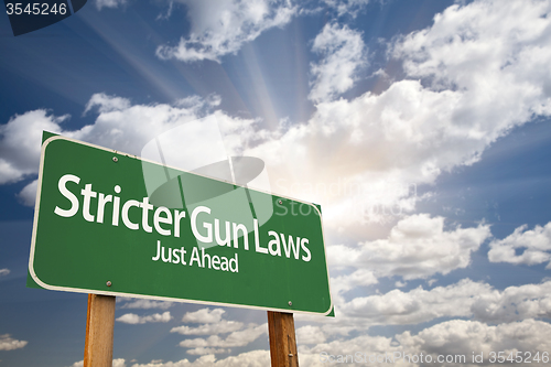 Image of Stricter Gun Laws Green Road Sign Over Clouds