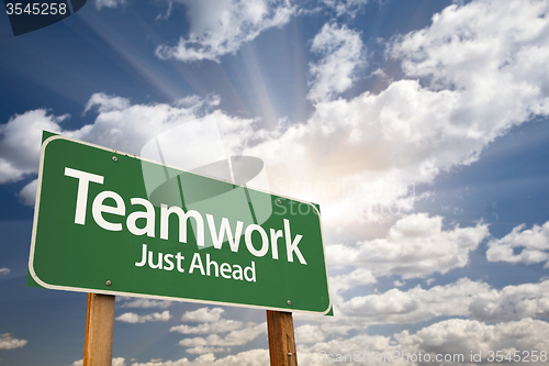 Image of Teamwork Green Road Sign Over Clouds