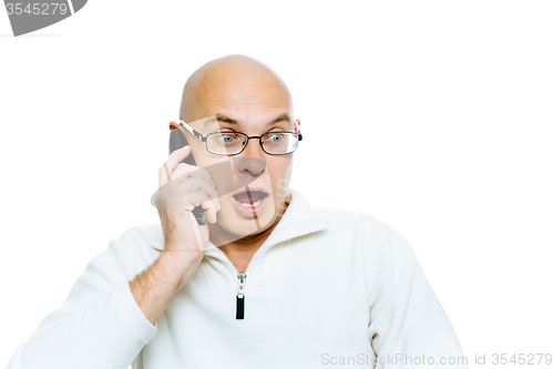 Image of Bald man emotionally communicates by phone. Isolated. Studio