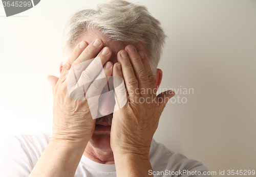 Image of Man covers his face. 