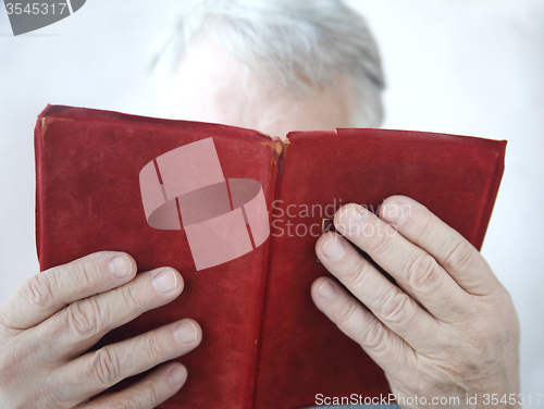 Image of older man reading a book