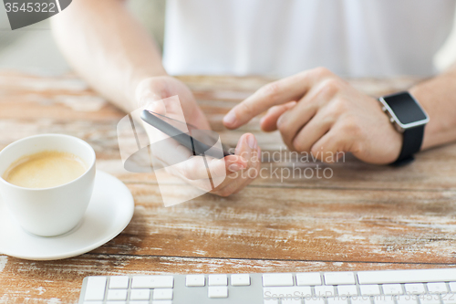 Image of close up of hands with smart phone and watch