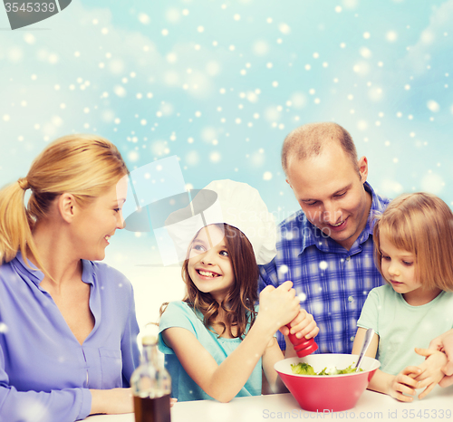 Image of happy family with two kids making salad at home