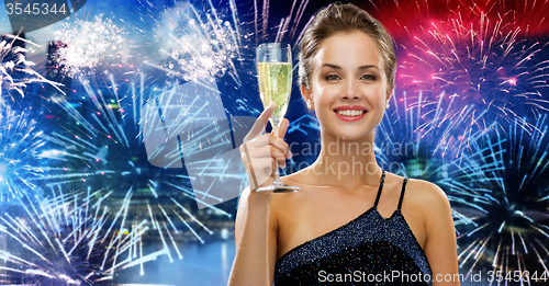 Image of happy woman with glass of champagne over firework