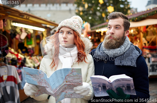 Image of happy couple with map and city guide in old town