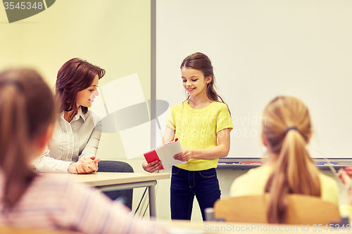 Image of group of school kids with teacher in classroom