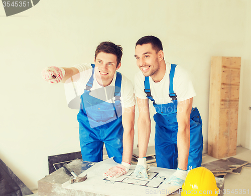 Image of group of builders with blueprint