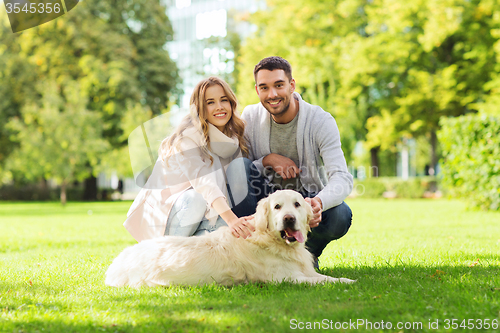 Image of happy couple with labrador dog walking in city