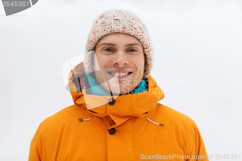 Image of happy young man in winter clothes outdoors