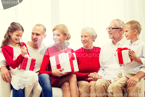 Image of smiling family with gifts at home