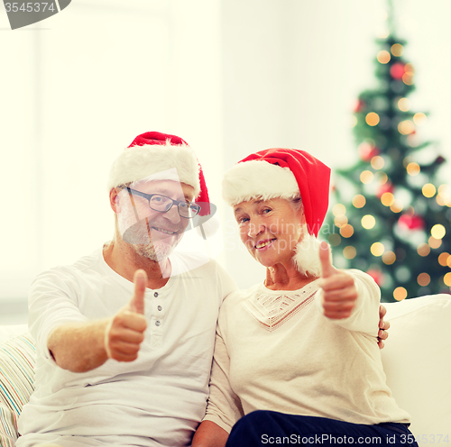 Image of happy senior couple in santa helper hats