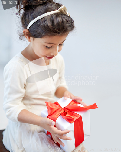 Image of happy little girl with gift box at home