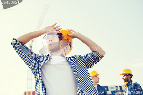 Image of group of builders in hardhats outdoors