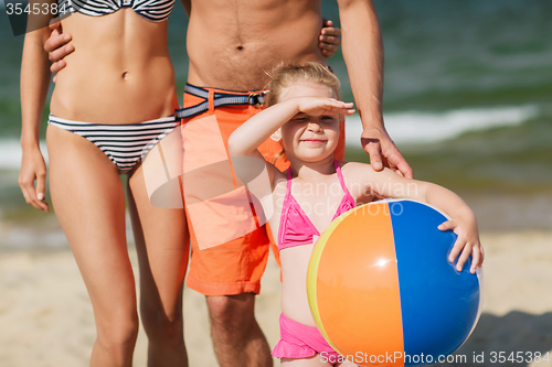 Image of close up of family with inflatable ball on beach