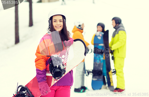 Image of happy friends in helmets with snowboards