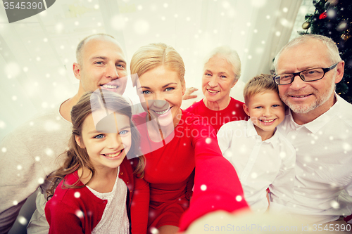 Image of smiling family making selfie at home