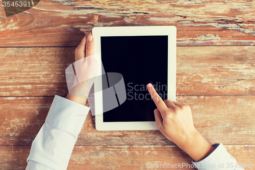 Image of close up of female hands with tablet pc on table
