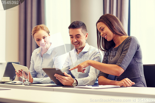 Image of smiling business people with tablet pc in office