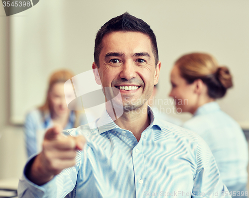 Image of group of smiling businesspeople meeting in office