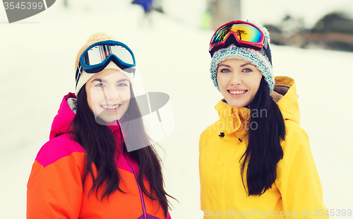 Image of happy girl friends in ski goggles outdoors