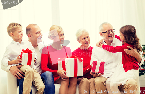 Image of smiling family with gifts at home