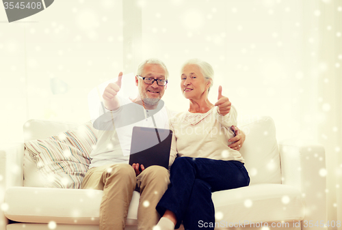 Image of happy senior couple with tablet pc at home