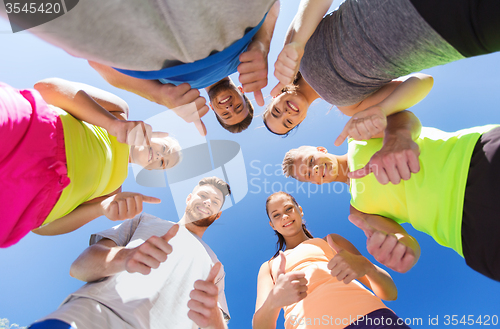 Image of group of happy sporty friends showing thumbs up