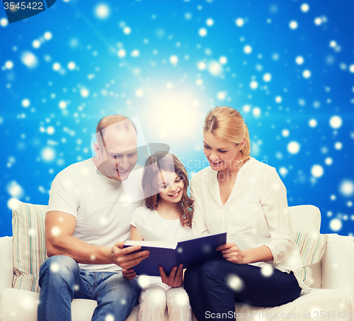 Image of happy family with book at home