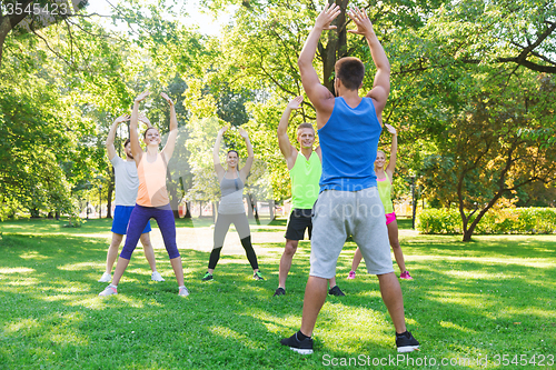 Image of group of friends or sportsmen exercising outdoors