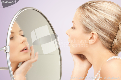 Image of beautiful woman with pearl necklace and mirror