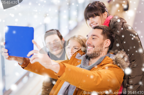 Image of happy friends with tablet pc on skating rink