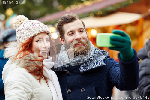 Image of couple taking selfie with smartphone in old town