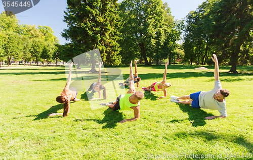 Image of group of happy friends exercising outdoors