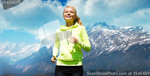 Image of happy sporty woman running or jogging outdoors