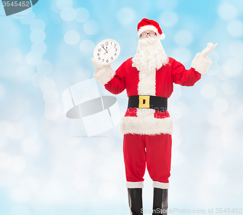 Image of man in costume of santa claus with clock